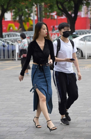 风度翩翩的开叉牛仔裙高跟靓女