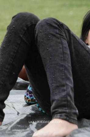 街拍短丝袜美眉躺着草地上与男友聊天