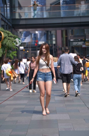 牵着狗狗的性感热裤美女