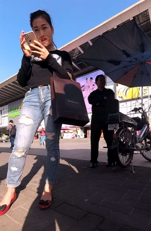 紧身破洞牛仔裤黑色毛衣美女等公交车