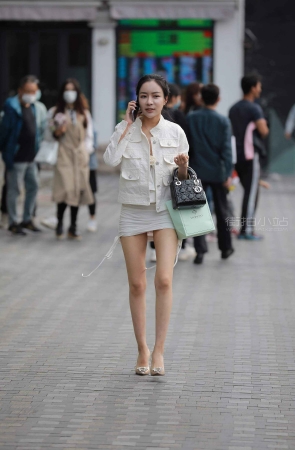 街拍打电话的短裙高跟美女